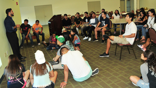 Kevin Noriega (standing, far left), the advisor for the DSU Opportunity Scholarship students, meets with them after their arrival to Del State in August.